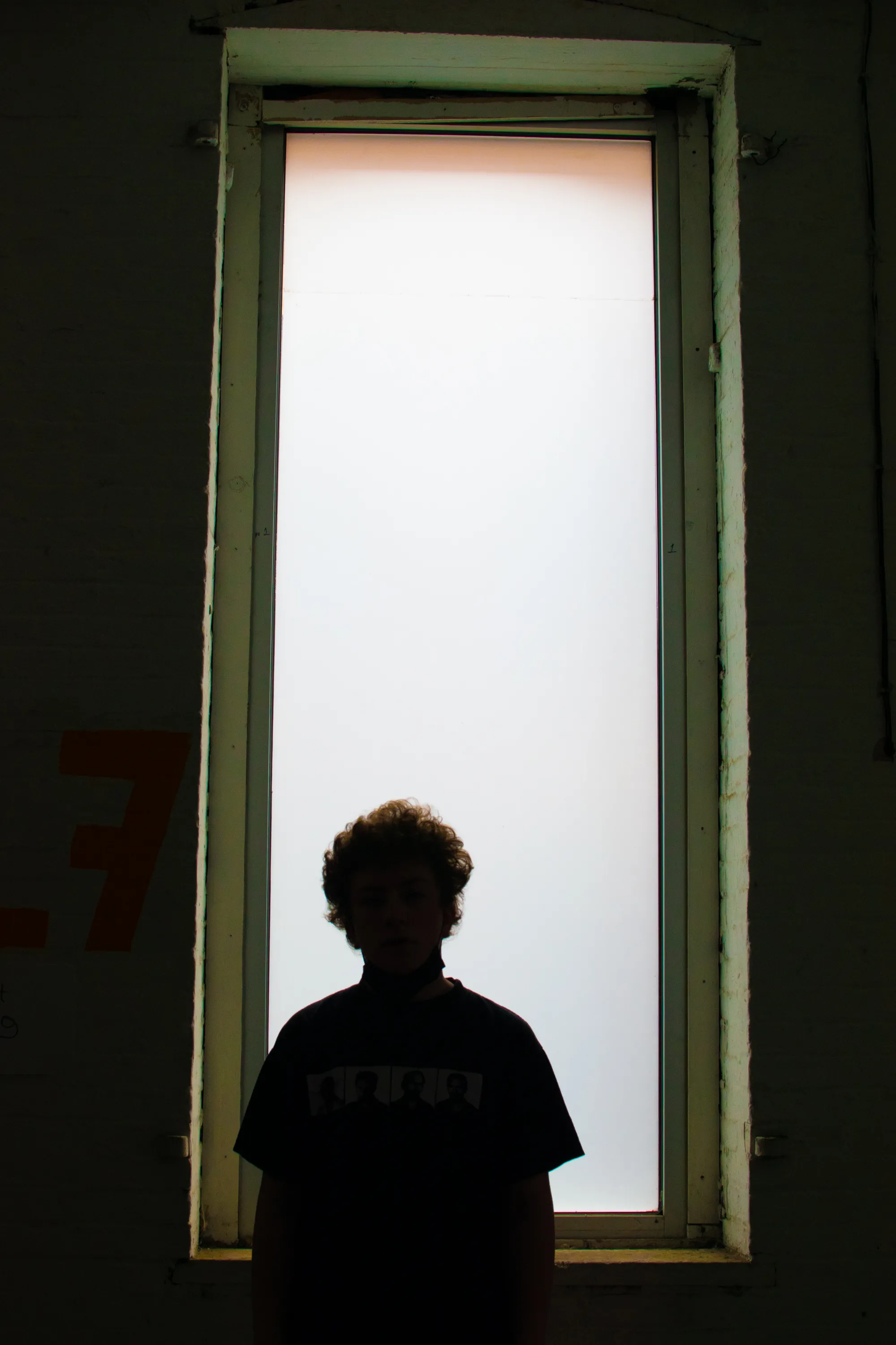 Kid looking out a tall window